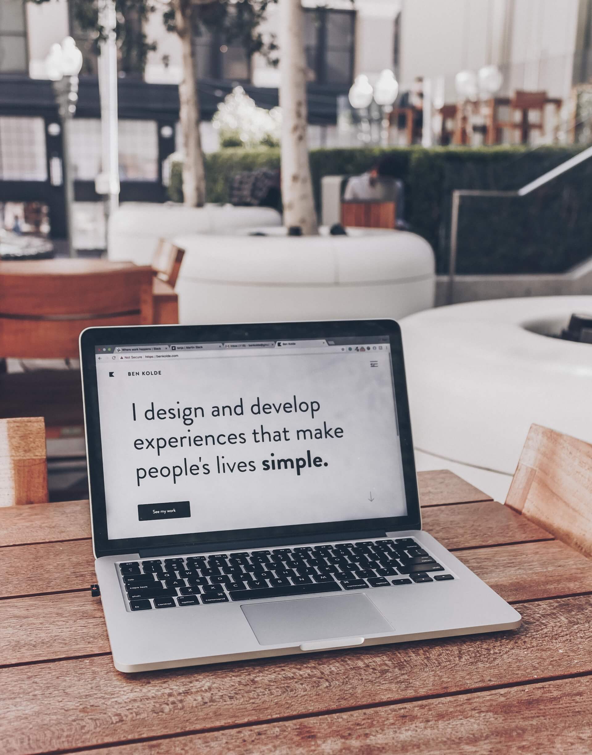 Laptop mit Text "I design and develop experiences that make people's lives simple."